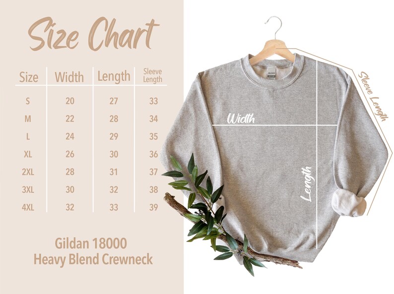 May include: A light gray Gildan 18000 Heavy Blend Crewneck sweatshirt hanging on a wooden hanger. The image includes a size chart with measurements in inches for width, length, and sleeve length. A sprig of greenery is in the lower left corner.