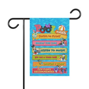 May include: A colourful garden flag with a blue background and a cartoon image of Mickey Mouse and other Disney characters. The flag has the text "Pool Rules" and a list of rules for enjoying the pool, including "Swim or Float", "Enjoy the Sun", "Listen to Music", "Sip on a Cold One", "Laugh & Play", and "Flip Flops Recommended".