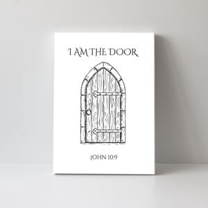 May include: A canvas print featuring a black and white illustration of a wooden door with an arched top. The text "I AM THE DOOR" is above the door, and "JOHN 10:9" is below it. The artwork is displayed on a white background.