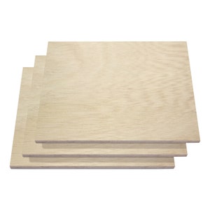 May include: Four light-colored wooden panels stacked on top of each other. The wood grain is visible, and the panels appear to be square or rectangular. The wood has a natural, light tan color.