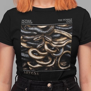 May include: Black t-shirt with a graphic of a pile of snakes and the text "Mother Monster The Female Gaze Medusa".
