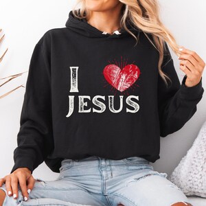 This lightweight Hoodie is made from 100% ring-spun cotton, featuring a jersey-lined hood and rolled forward shoulders for enhanced comfort. It has a relaxed fit, perfect for casual wear.