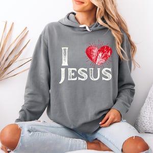 May include: Gray hooded sweatshirt with a red heart and the text "I love Jesus" in white.