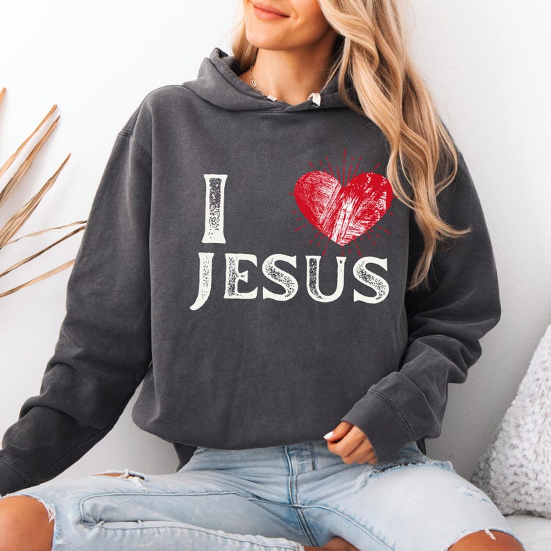 May include: A charcoal gray hoodie with a white graphic that says "I love Jesus" with a red heart in the middle.