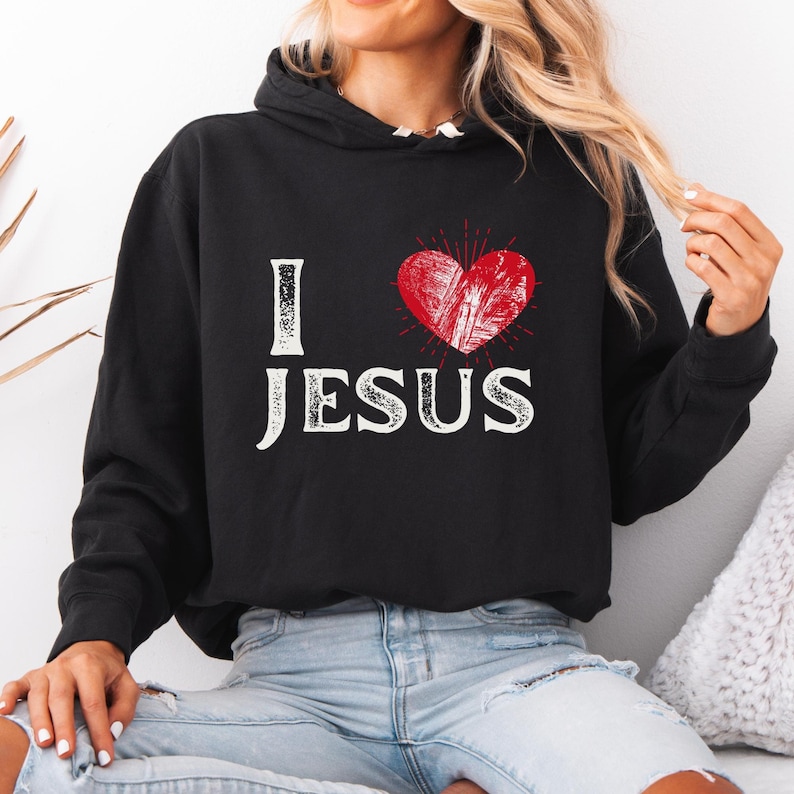 This lightweight Hoodie is made from 100% ring-spun cotton, featuring a jersey-lined hood and rolled forward shoulders for enhanced comfort. It has a relaxed fit, perfect for casual wear.
