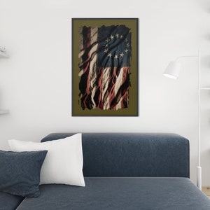 May include: A distressed, faded American flag with 13 stars in a circle. The flag is tattered and torn, with the red, white, and blue colors showing through the damage. The flag is framed in a dark brown frame.