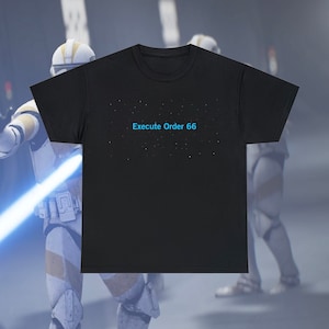 Peut inclure: T-shirt noir avec le texte "Exécuter l'ordre 66" en bleu sur un fond foncé avec des points blancs.
