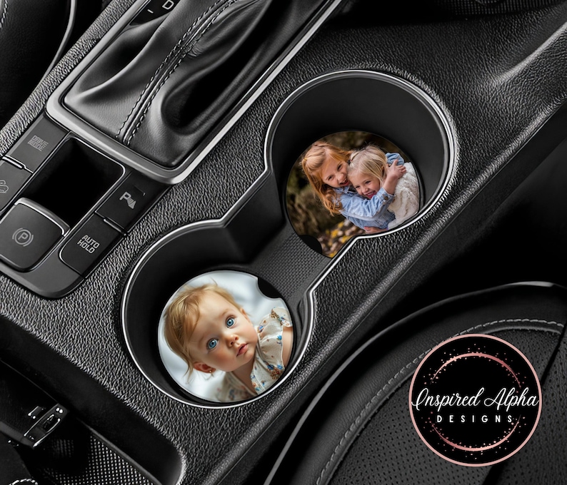 May include: Two car coasters with personalized photos. The first coaster features a photo of two young girls smiling. The second coaster features a photo of a young child with brown hair and blue eyes. The coasters are round and have a white background.