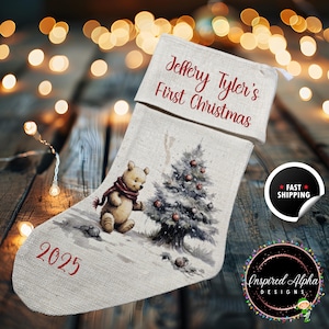May include: A personalized Christmas stocking with the text "Jeffery Tyler's First Christmas" in red script. The stocking features a watercolor illustration of a teddy bear, a Christmas tree, and the year "2025".