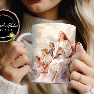 May include: White ceramic mug with a colorful image of four angels with wings, surrounded by clouds. The angels are wearing white robes and have their hands clasped in prayer. The mug has a handle on the left side.