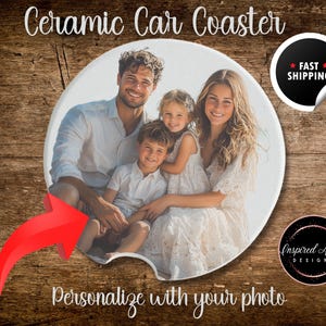 May include: Ceramic car coaster with a photo of a family of four on a beach. The coaster is round and white with a beveled edge. The photo shows a man, a woman, and two children. The man is wearing a blue shirt and the woman is wearing a white dress. The children are wearing casual clothing. The coaster is personalized with the family's photo.