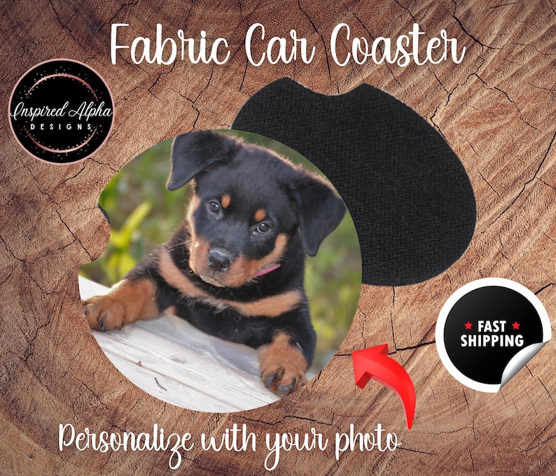 May include: A black and tan puppy with a pink collar is looking at the camera. The puppy is on a white wooden surface. The image is in a circle shape and is surrounded by a wooden background. The text "Fabric Car Coaster" is at the top of the image. The text "Personalize with your photo" is at the bottom of the image.