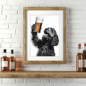 Puede incluir: Una impresión en blanco y negro enmarcada de un perro sosteniendo una jarra de cerveza. El perro, un cruce de caniche negro, tiene una expresión alegre. La impresión está en un marco de madera y se exhibe en un estante de madera con botellas de licor.