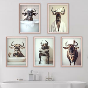 May include: Five framed art prints featuring anthropomorphic bulls in a bathroom setting. One bull is in a bathtub, another in a robe, one brushing its teeth, one on the toilet reading, and one with a toilet paper roll on its head.