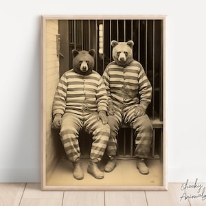 May include: Two bears wearing striped prison uniforms sit on a bench in a jail cell. The photo is in black and white and has a vintage look.