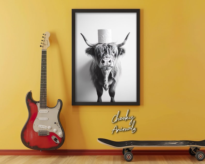 May include: Black and white photograph of a Highland cow wearing a toilet paper roll as a hat. The image is framed and has the text "Cheeky Animals" below it.