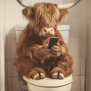 May include: A brown and white Highland cow sits on a white toilet seat, holding a black smartphone in its front paws.