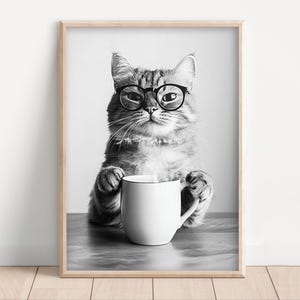May include: A black and white photo of a cat wearing glasses and holding a white coffee mug.