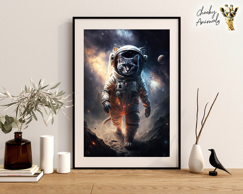 May include: A framed print of a cat wearing an astronaut suit in space. The cat is looking at the camera with a serious expression. The background is a dark blue with stars and planets.