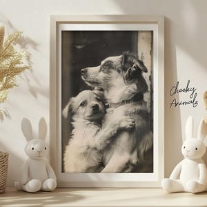 May include: A framed monochrome print of two dogs in an embrace. The larger dog's head rests on the smaller dog, which is hugging it. The print is in a white frame. The text "Cheeky Animalz" is in the lower right corner of the image.