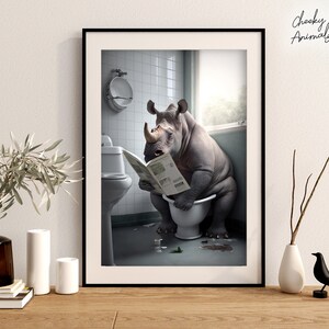 Peut inclure: Une illustration humoristique d'un rhinoc&eacute;ros assis sur des toilettes dans une salle de bain, en train de lire un journal. Le rhinoc&eacute;ros a une expression s&eacute;rieuse et est entour&eacute; de quelques objets &eacute;parpill&eacute;s sur le sol.
