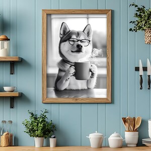 May include: Black and white photo of a dog wearing glasses and holding a mug of coffee. The dog is sitting in front of a window. The photo is framed in a brown wooden frame.
