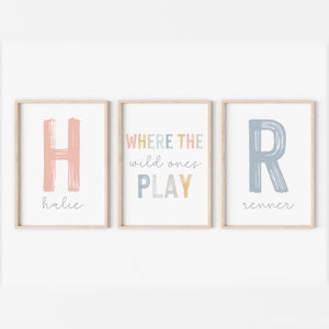 May include: Three framed prints with a colorful, brushstroke font. The left print features the letter "H" and the name "halie". The middle print says "WHERE THE wild ones PLAY". The right print features the letter "R" and the name "renner".