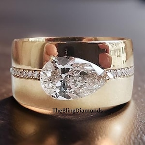 Anillo de compromiso East To West de moissanita incolora talla pera de 12 x 8 mm, anillo de oro amarillo de 18 quilates con banda ancha y engaste pavé de diamantes redondos centrales. Regalo ideal.