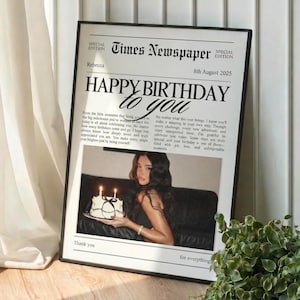 Op de afbeelding: Een ingelijste krantenprint met de kop "HAPPY BIRTHDAY to you". De print bevat een foto van een persoon die een taart vasthoudt met brandende kaarsen. De datum op de print is 8 augustus 2025.