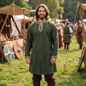 May include: A long-sleeved olive green tunic featuring a split neckline and cuffs adorned with intricate gold-toned embroidery. The garment reaches mid-thigh and is worn over dark brown trousers, showcasing a clean, structured design.