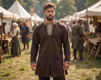 May include: A long-sleeved brown tunic featuring a V-neckline with white lace-up detailing and a decorative gold and black patterned trim along the collar and cuffs. The garment has a straight hem with a center slit at the front.