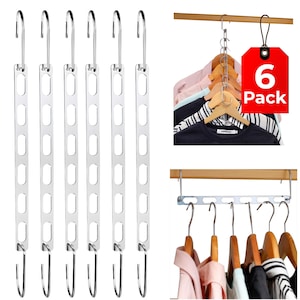 May include: A set of six silver metal space-saving clothing hangers with multiple slots for hanging clothes. The image also shows a 6-pack tag and clothes hanging on wooden hangers, demonstrating the product's use.