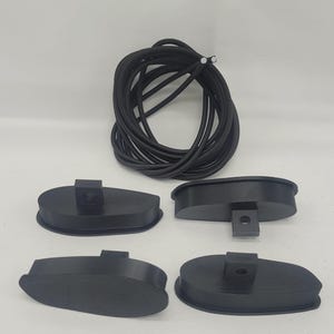 May include: Four black plastic oval-shaped objects with a small black post on top. A black elastic cord is also included.