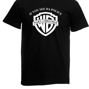 Könnte beinhalten: Schwarzes T-Shirt mit einem weißen Warner Bros. Logo und dem Text "If you see da police warn a brother".