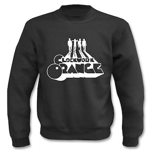 Könnte beinhalten: Ein schwarzer Pullover mit einer weißen Grafik von vier Figuren, die in einer Reihe gehen. Die Grafik enthält den Text "Clockwork Orange".