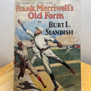 May include: A vintage book cover featuring an illustration of a baseball game. The cover is titled "Frank Merriwell's Old Form" by Burt L. Standish. The book is part of The Merriwell Series, No. 184.