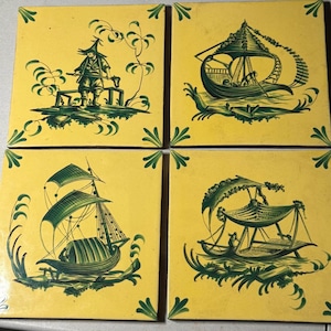 May include: Set of four square ceramic tiles with a yellow background and green illustrations. Each tile features a different scene, including figures and boats, with decorative green corner accents. The tiles are likely for decorative use.