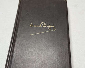 May include: A dark brown book with gold lettering that reads "Warwick Deeping" in a cursive font. The book has a textured cover and appears to be an older edition. The book is closed and resting on a light-colored surface.