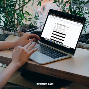 May include: A person working on a laptop computer with a document open on the screen titled "Standard Operating Procedure".