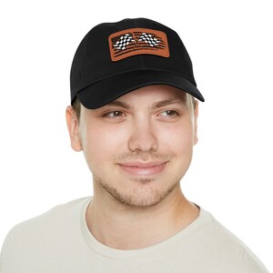 May include: A black baseball cap with a brown patch featuring two crossed checkered flags.