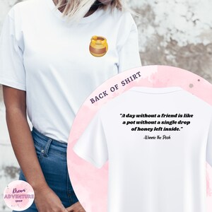 May include: White t-shirt with a honey pot graphic on the front and a quote from Winnie the Pooh on the back. The quote reads: "A day without a friend is like a pot without a single drop of honey left inside." -Winnie the Pooh