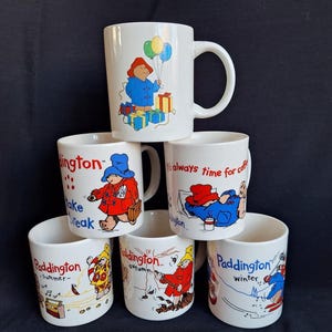 verschiedene Douwe Egberts Paddington-Tassen, darunter vier Jahreszeiten