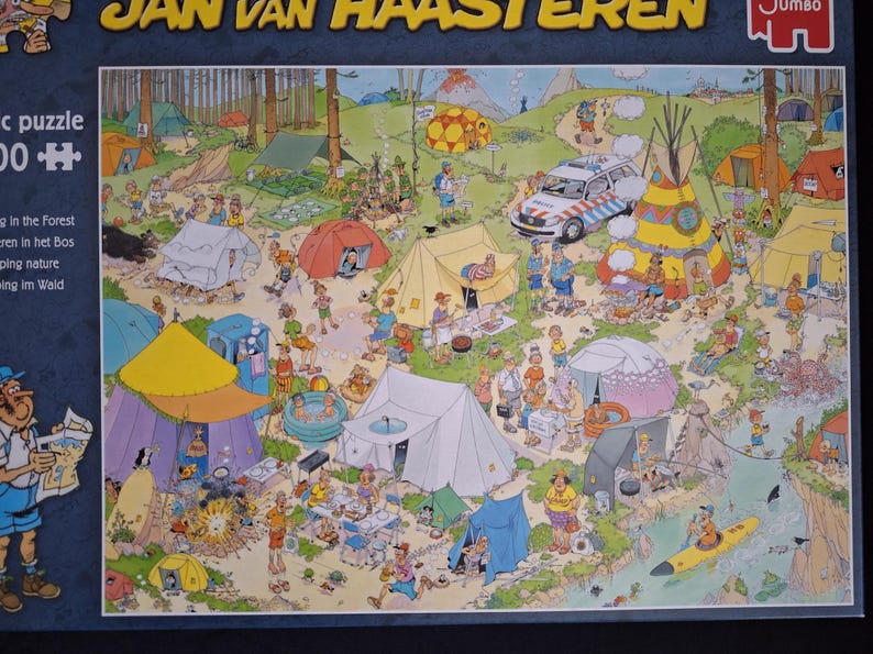 May include: A detailed jigsaw puzzle depicting a camping scene in a forest, with numerous tents, people, and a police vehicle. The puzzle is titled "Jan van Haasteren" and is made by "Jumbo". The scene includes various outdoor activities.