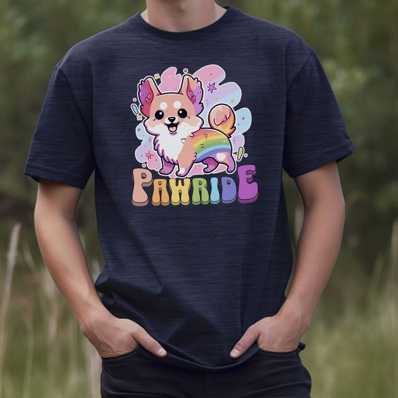 Puede incluir: Una camiseta azul marino con una imagen de dibujos animados de un perro con una cola de arco&iacute;ris. El texto "PAWRIDE" est&aacute; impreso debajo del perro.