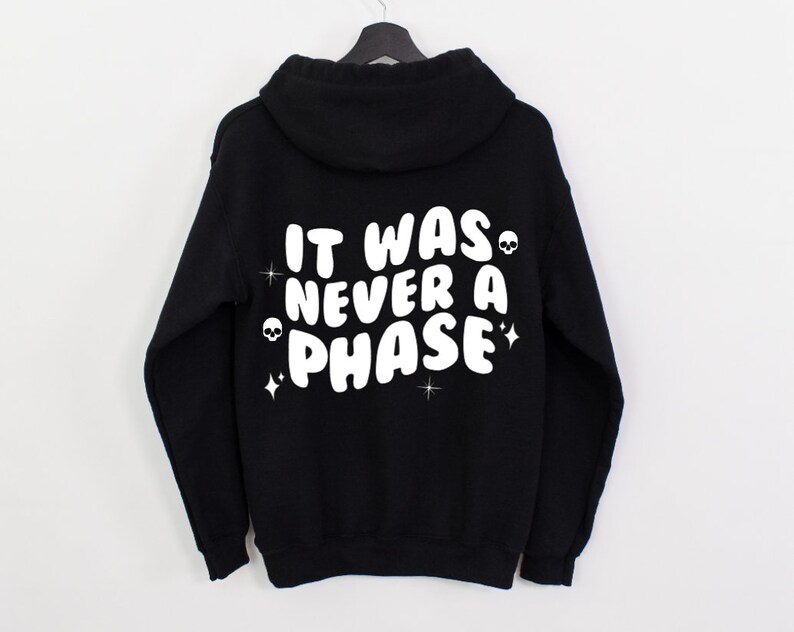 K&ouml;nnte beinhalten: Schwarzer Kapuzenpullover mit wei&szlig;em Text, der "It was never a phase" lautet, mit Totenkopf- und Stern-Akzenten.