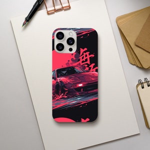 May include: A phone case featuring a red sports car illustration with Japanese characters. The design has a dynamic, artistic style with splashes of red, black, and gray. The case is shown on a white surface.