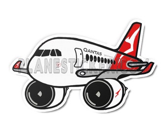 Può includere: Un aereo di cartone animato bianco con accenti rossi e le parole "QANTAS Spirit of Australia" sul lato. L'aereo ha ruote nere e una coda rossa con un logo di canguro.