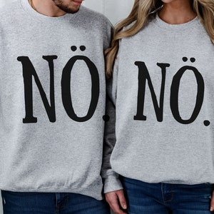 May include: Two gray sweatshirts with the word "NO" printed on them. The word "NO" is stylized with two dots above the "O".