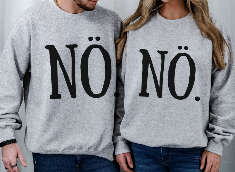 May include: Two gray sweatshirts with the word "NO" printed on them. The word "NO" is stylized with two dots above the "O".