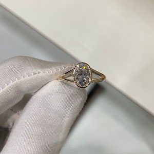 Op de afbeelding: Een gouden ring met een grote ovale diamant, gezet in een delicaat, gesplitst ontwerp.